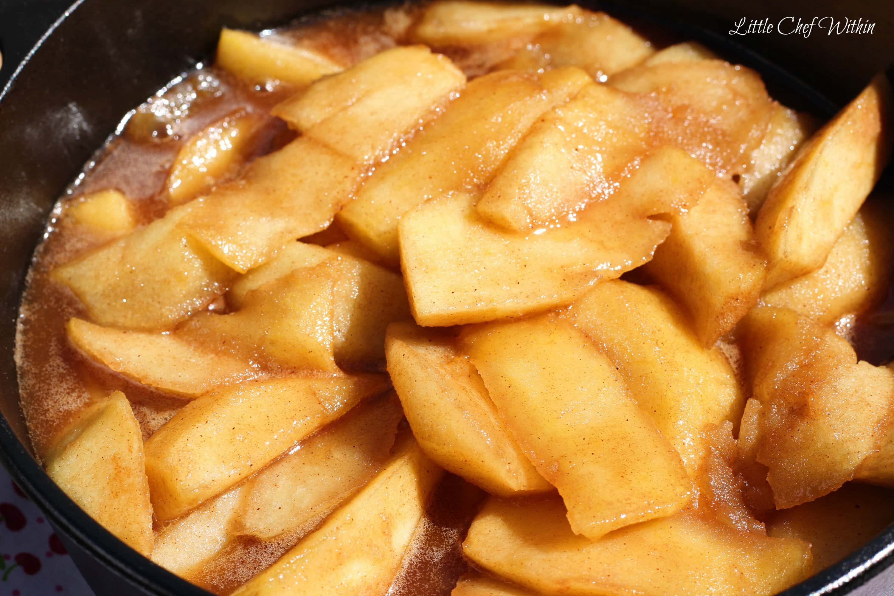 sliced apples cooked in butter in a cast iron skilled