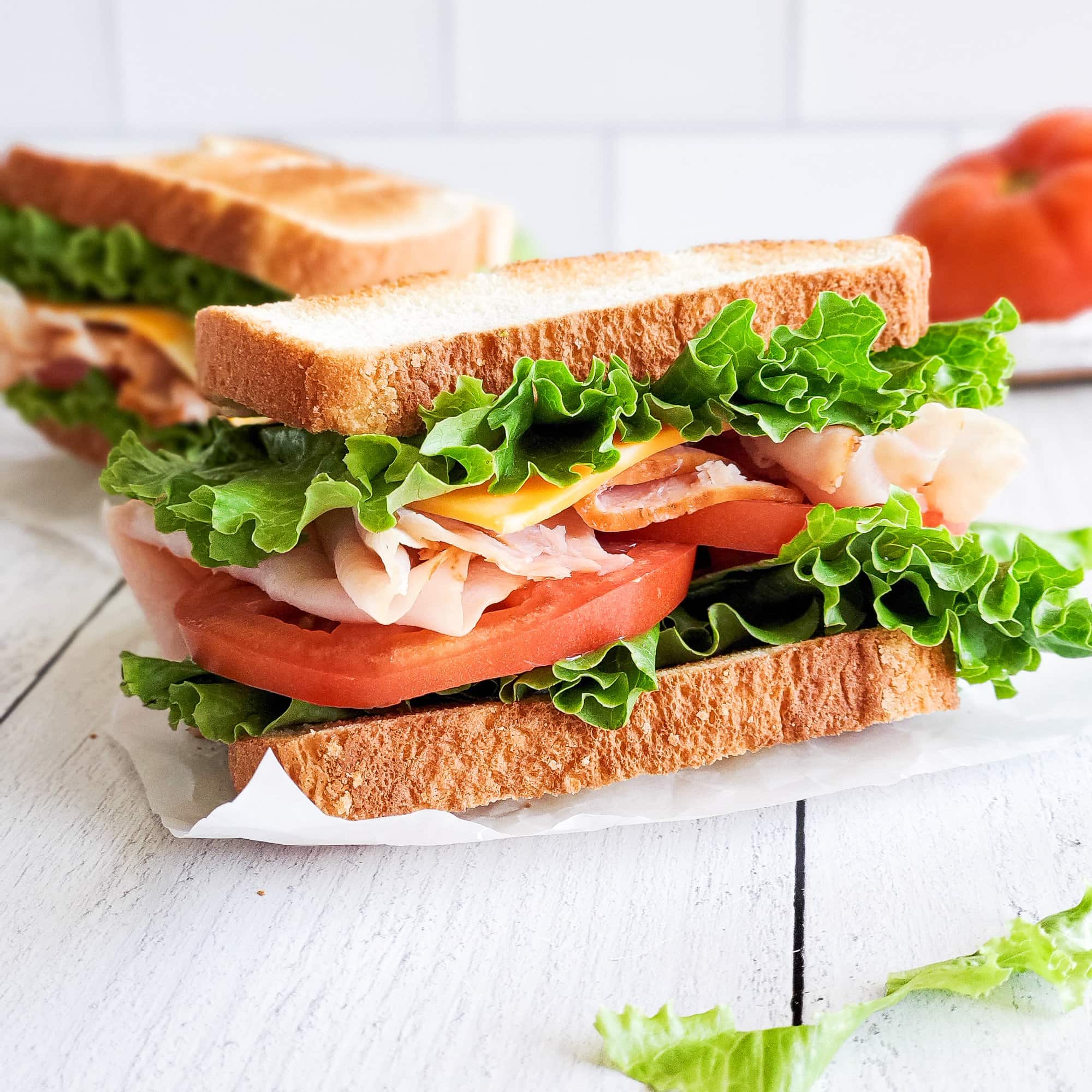 turkey sandwich on white bread with lettuce and tomato
