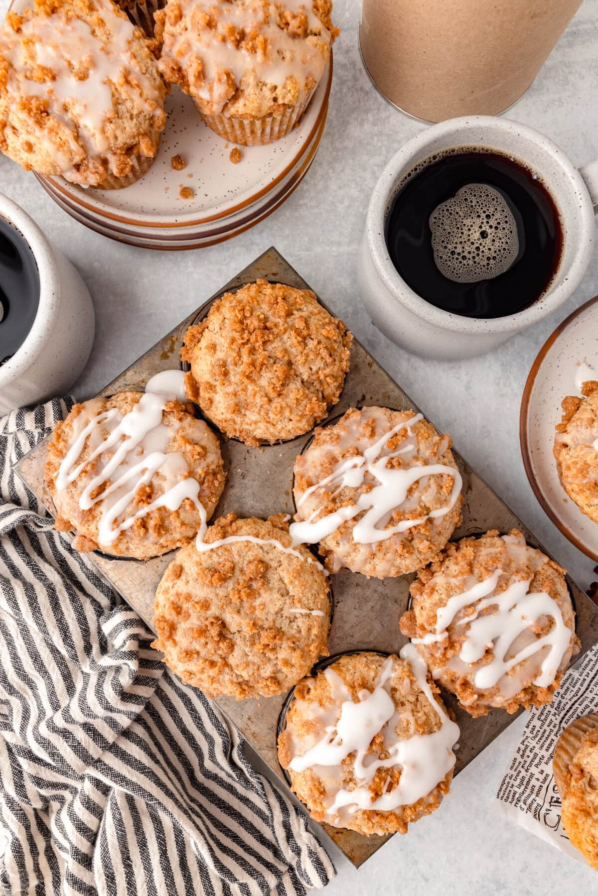 Cream cheese frosting and toasted pecans on cinnamon roll muffins.