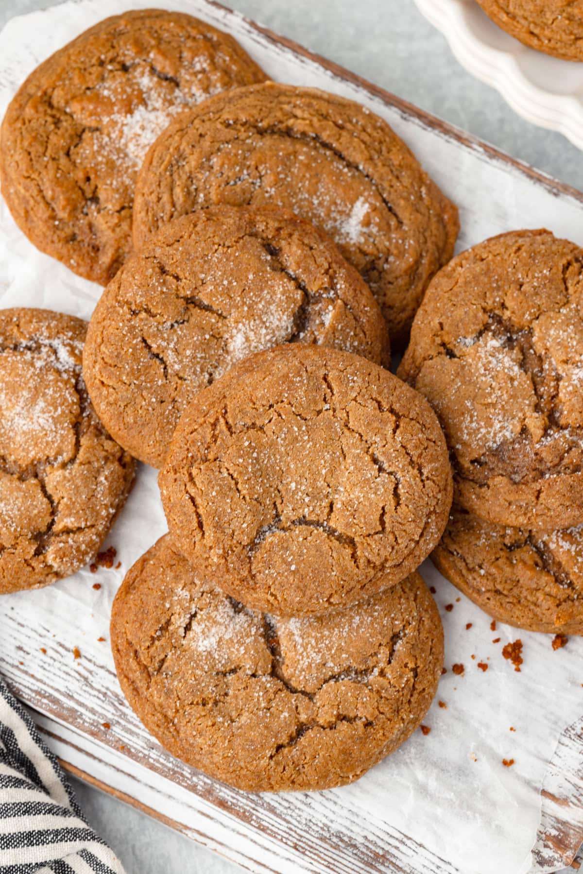 Soft, chewy chocolate chip cookies sprinkled with powdered sugar, resting on a baking sheet.