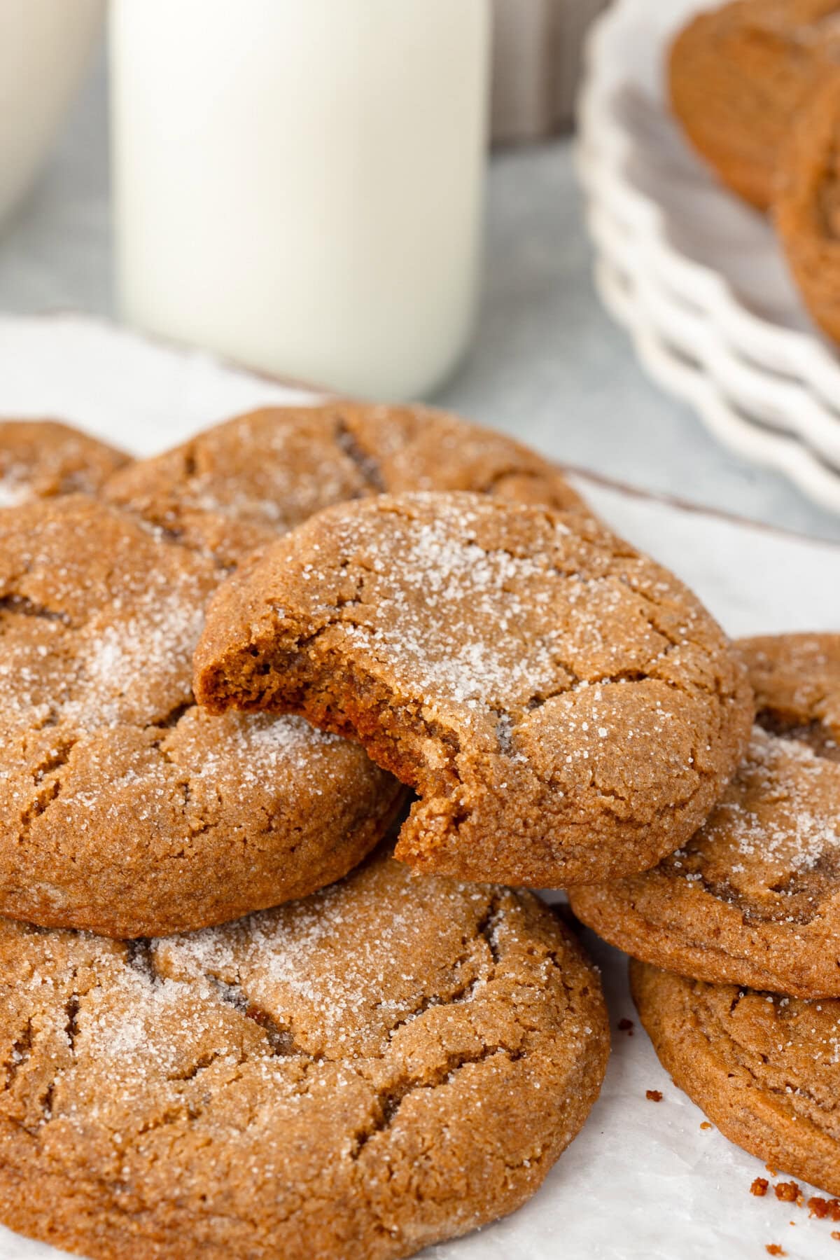 Soft, freshly baked chocolate chip cookies with a dusting of powdered sugar on a parchment paper.