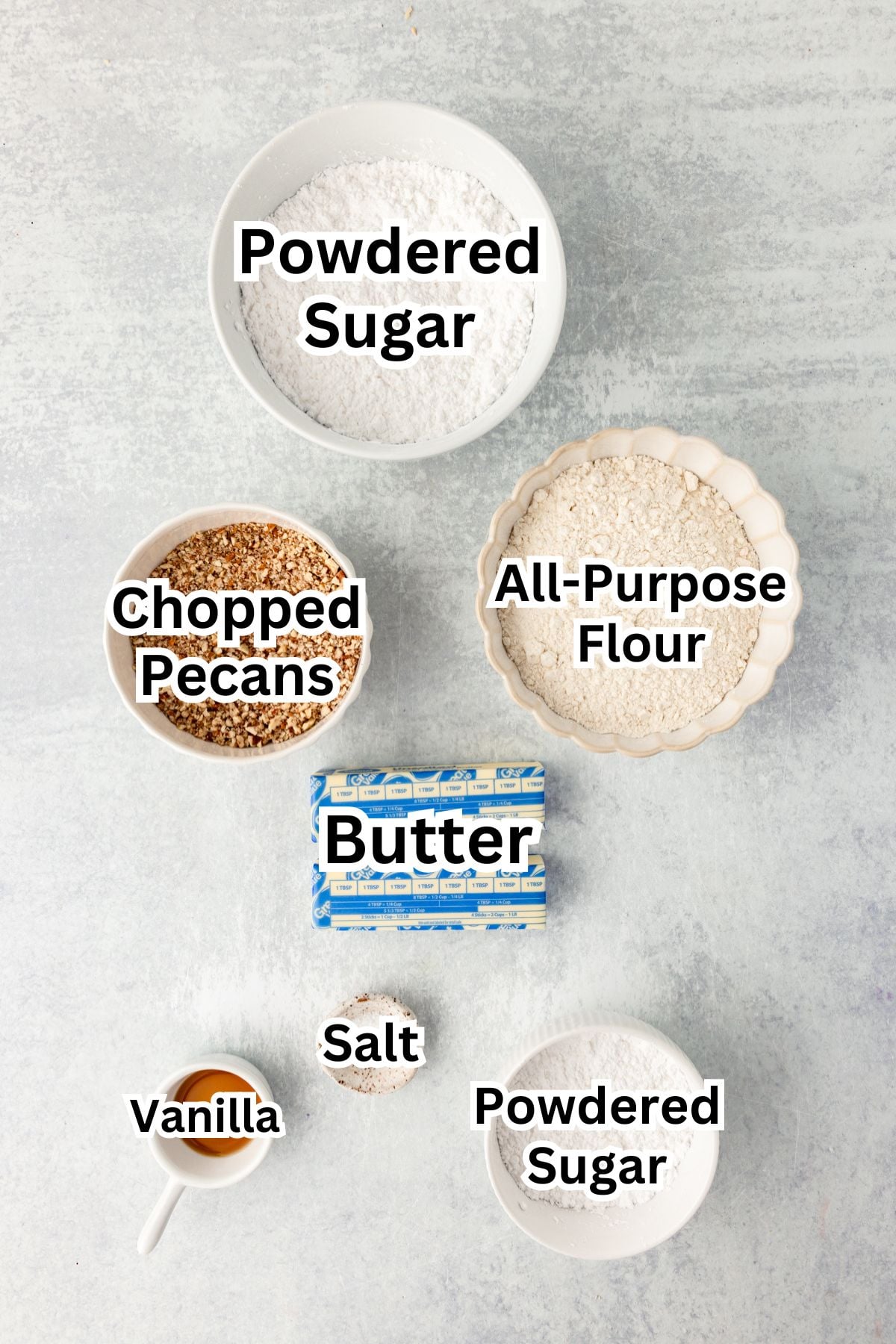 Powdered sugar and chopped pecans on a baking surface for dessert recipe.