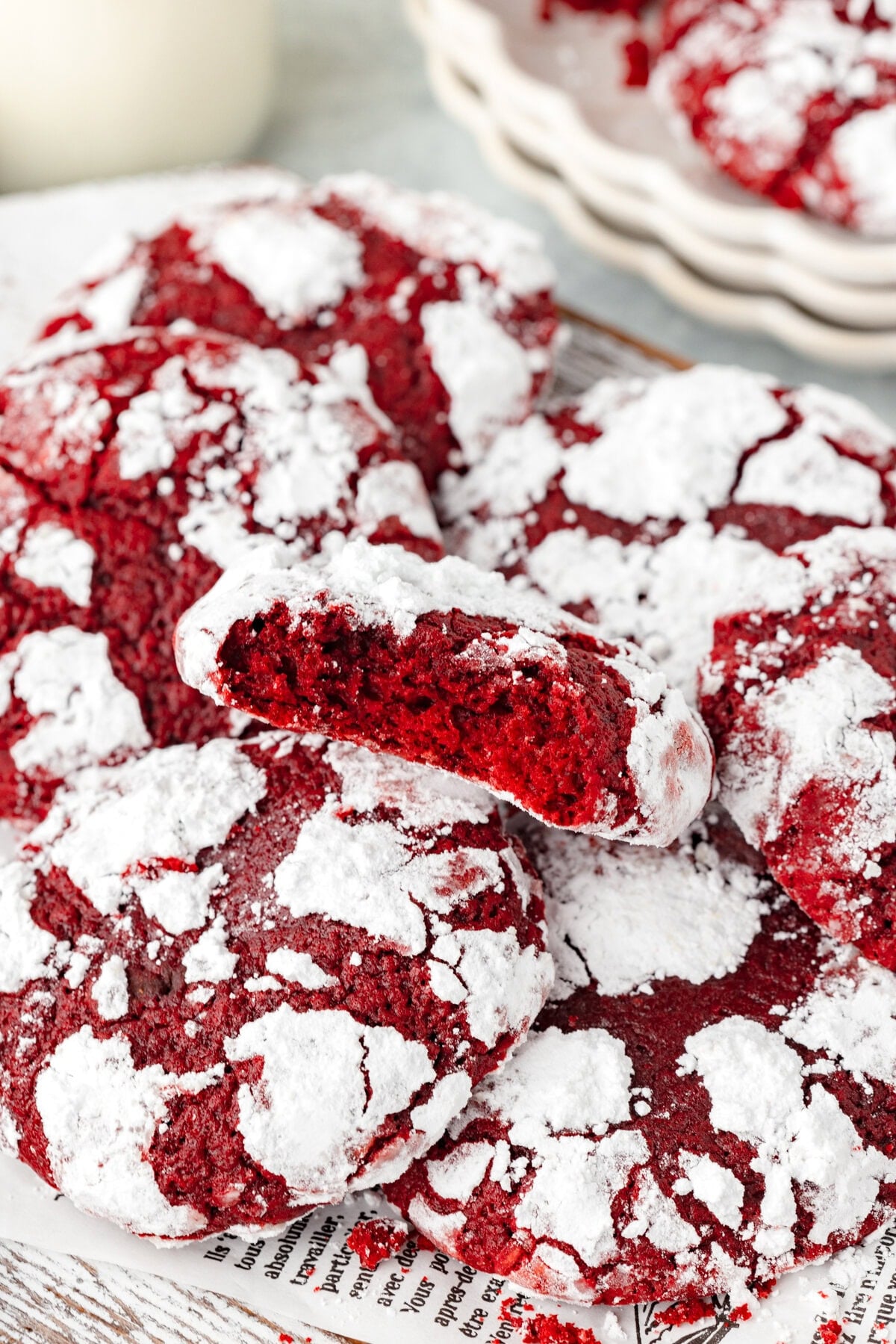 Red powdered cookies with cracked surface on parchment paper.