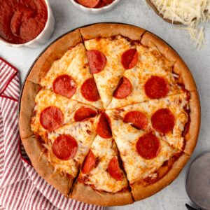 Sliced Pizza made with a freshly milled spelt flour crust, baked until golden and topped with cheese and pepperoni.