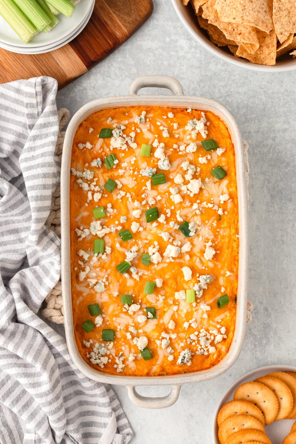 Creamy buffalo chicken casserole topped with blue cheese crumbles and green onions, ready to serve.