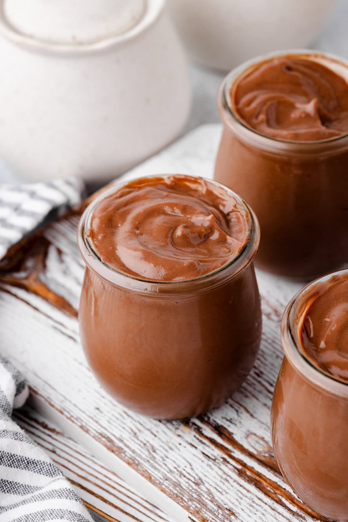 Creamy homemade chocolate pudding in glass jars.