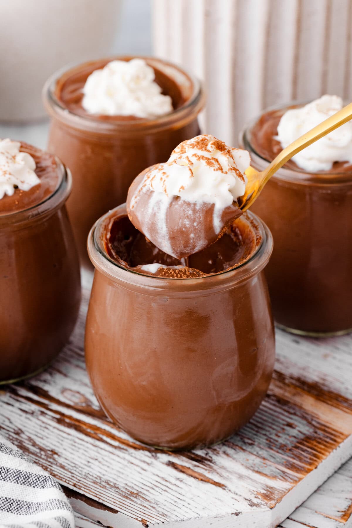 Delicious homemade chocolate pudding with whipped cream topping, perfect for a sweet treat.