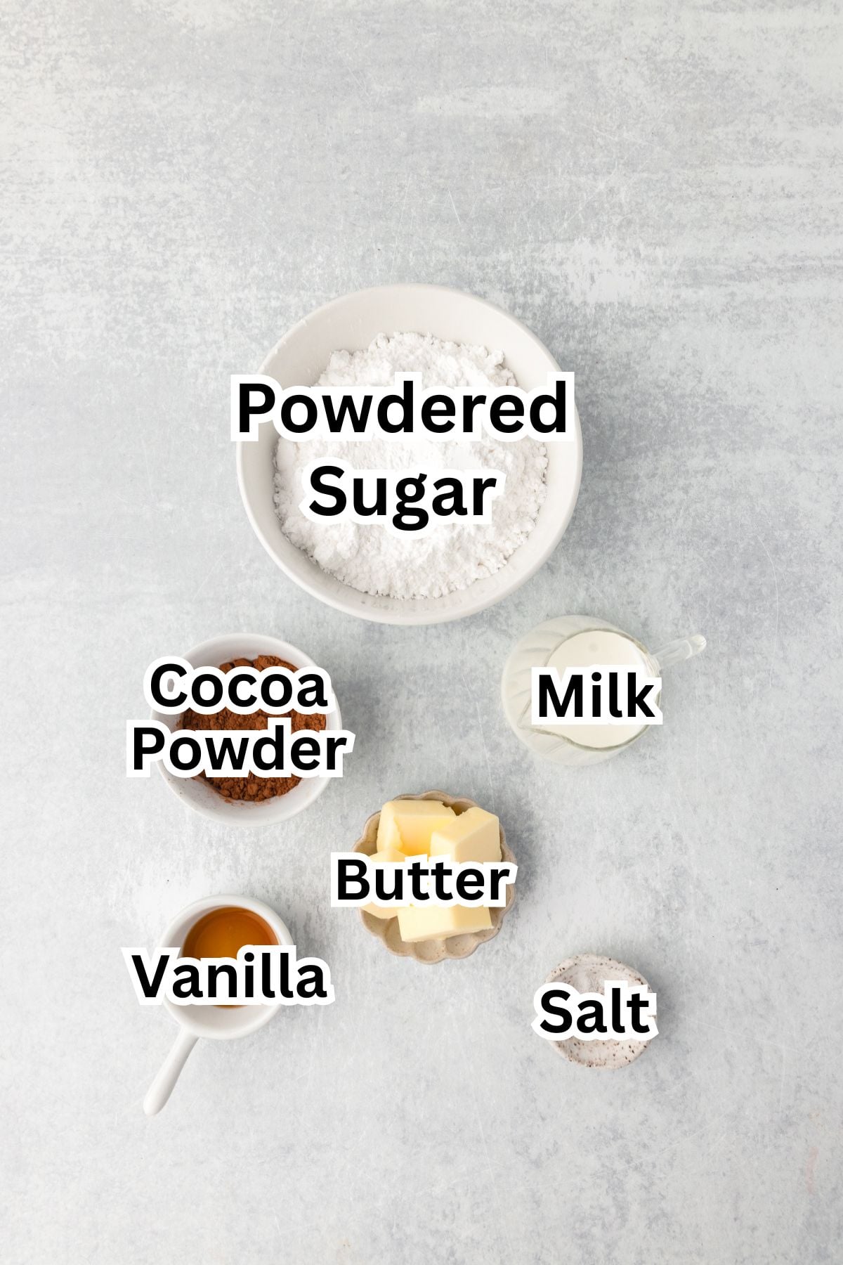 Chocolate cupcake ingredients with powdered sugar, cocoa powder, milk, butter, vanilla, and salt.