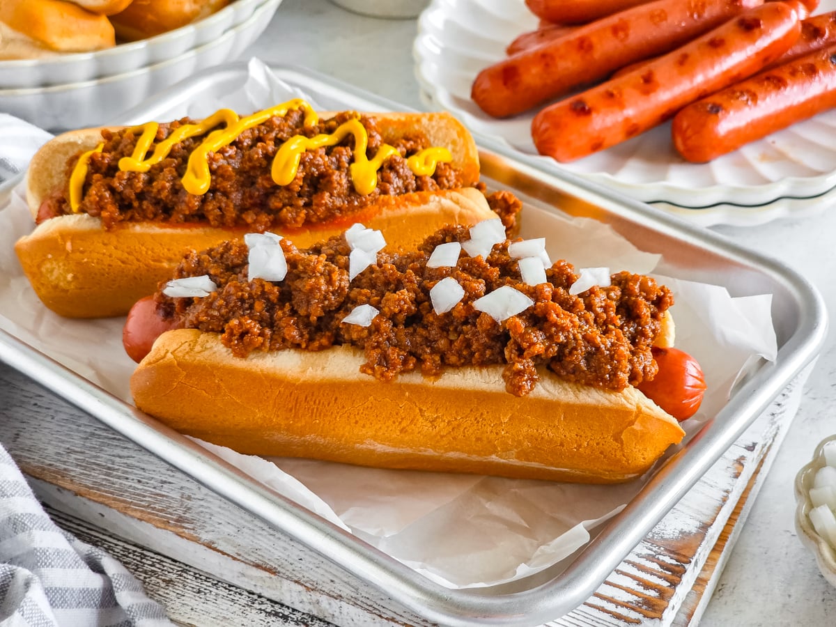 A hot dog with chili and mustard in a bun, crispy and savory.