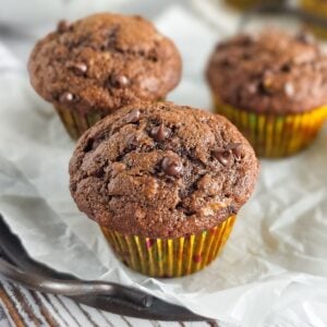 Einkorn chocolate chip banana muffins in colorful paper liners on parchment paper.