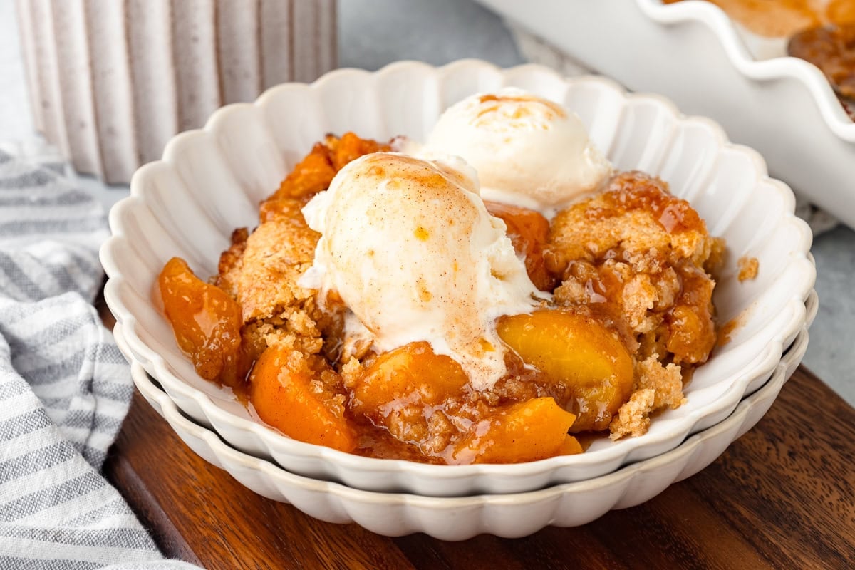 Peach Cobbler with Fresh Milled Flour in a white scalloped bowl.