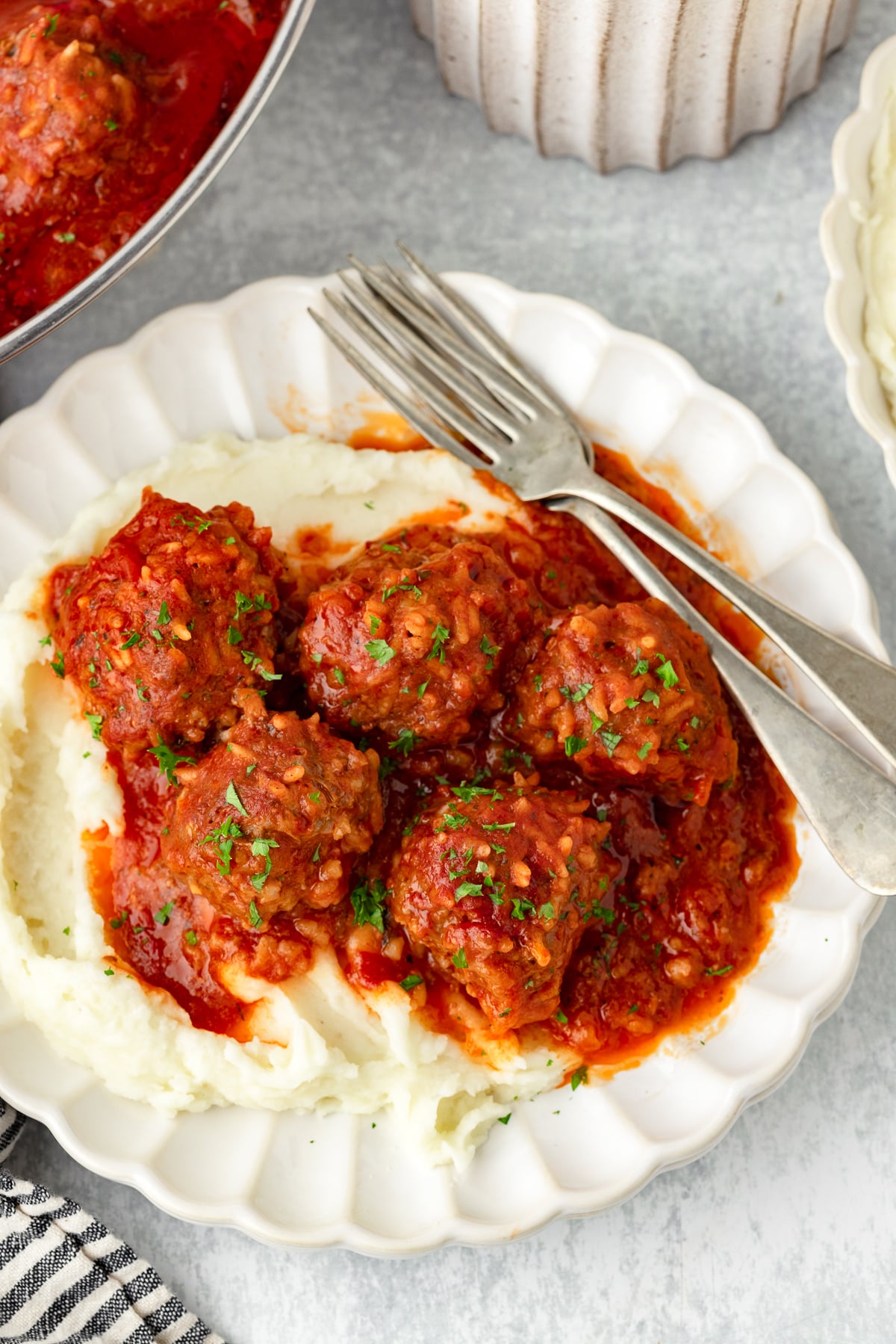 Porcupine Meatballs with tomato sauce served over mashed potatoes.