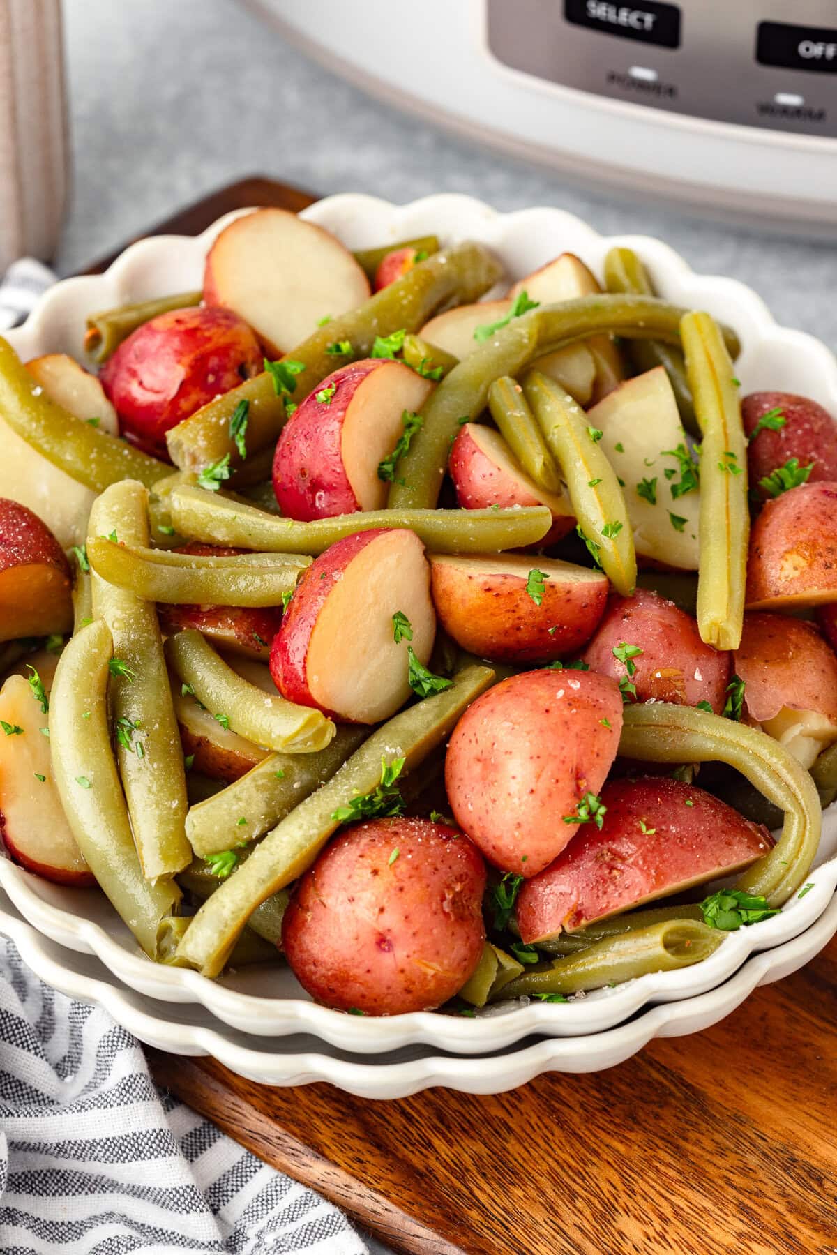 Fresh green beans and red potatoes in a white bowl, healthy side dish.