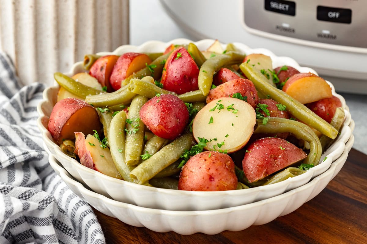 Fresh green beans and red potatoes in a white bowl for Slow Cooker Potatoes and Green Beans.