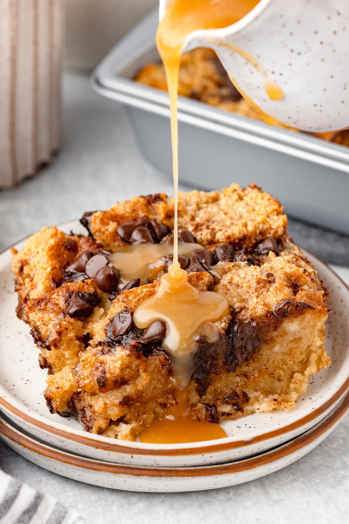 Biscuit bread pudding with caramel sauce and chocolate chips, creamy and baked.