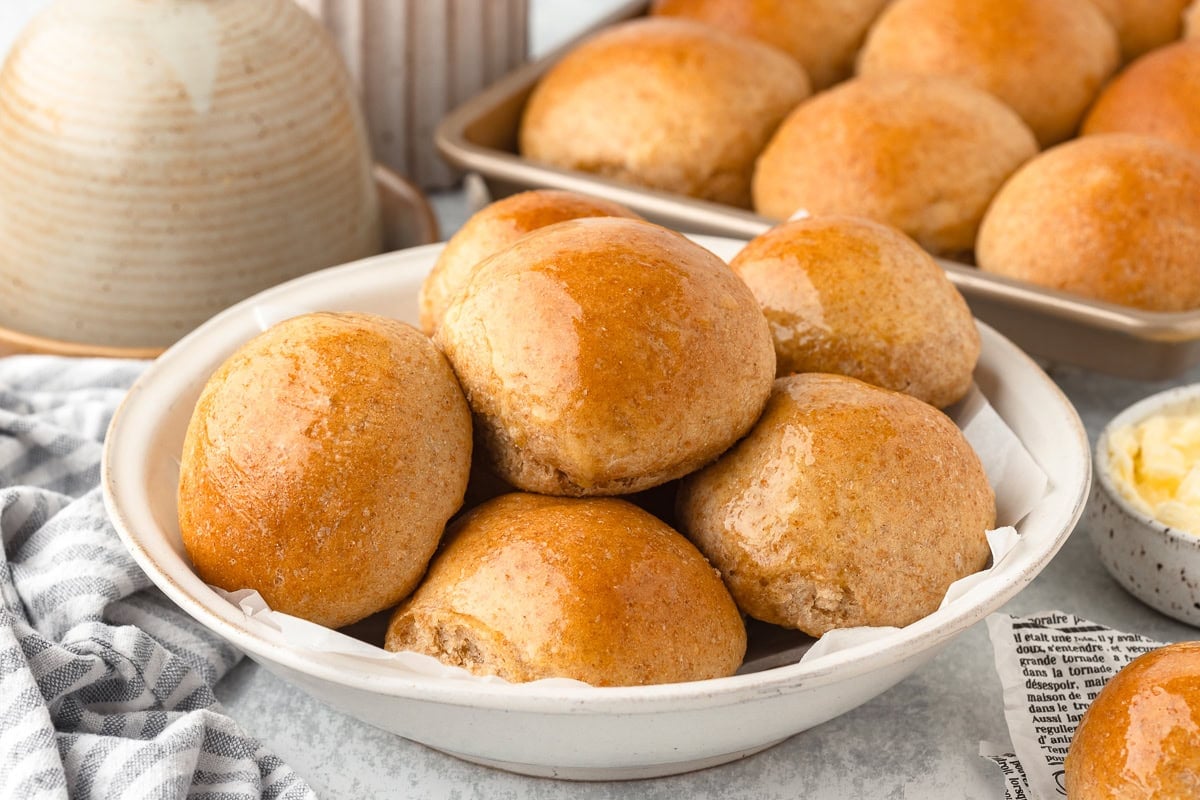 Fresh milled flour dinner rolls with golden crusts and soft interiors.