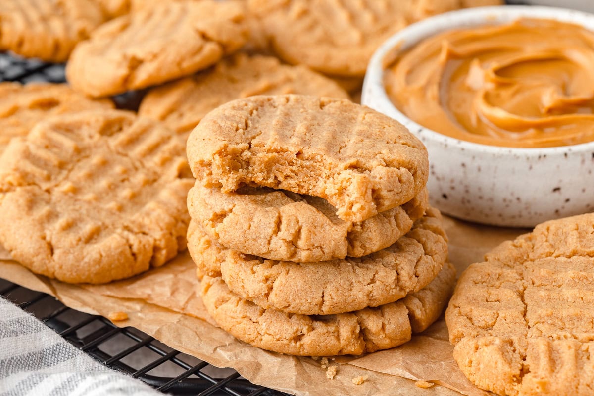 Fresh baked peanut butter cookies with a bowl of peanut butter on the side.