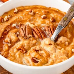 Pumpkin Cream of Wheat with Fresh Milled Flour in a white bowl with a spoon in it.